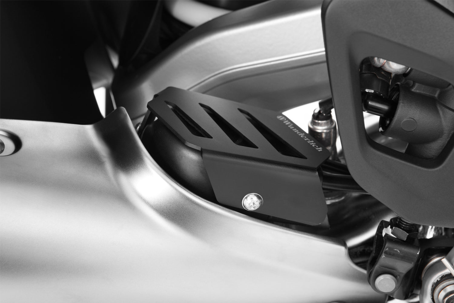 Damage from stones and accidental boot damage can no longer occur with this Wunderlich Exhaust flap cover.